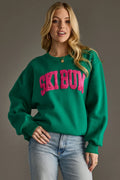 Green Ski Bum sweatshirt with a hot pink varsity-style patch, oversized fit and ribbed cuffs and hem.