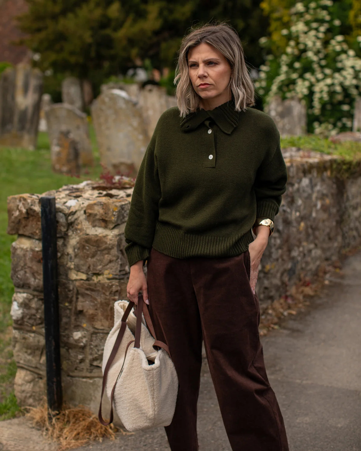 woman holding sherpa tote bag in autumn setting